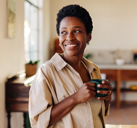 Smiling woman enjoying coffee at home