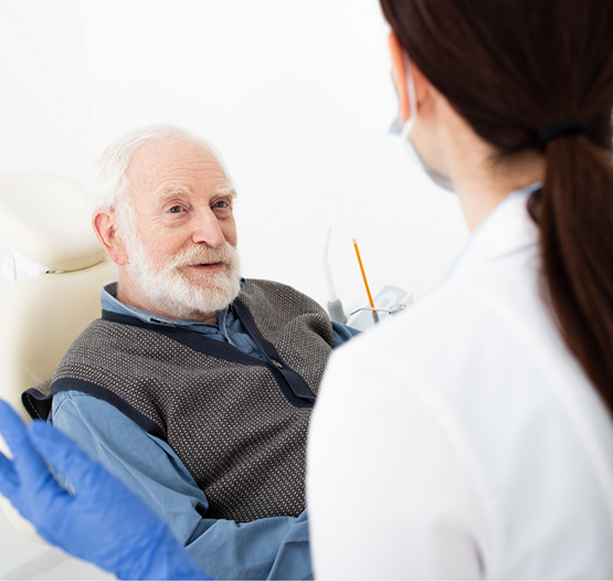 Senior man in the dental chair listening to his dentist