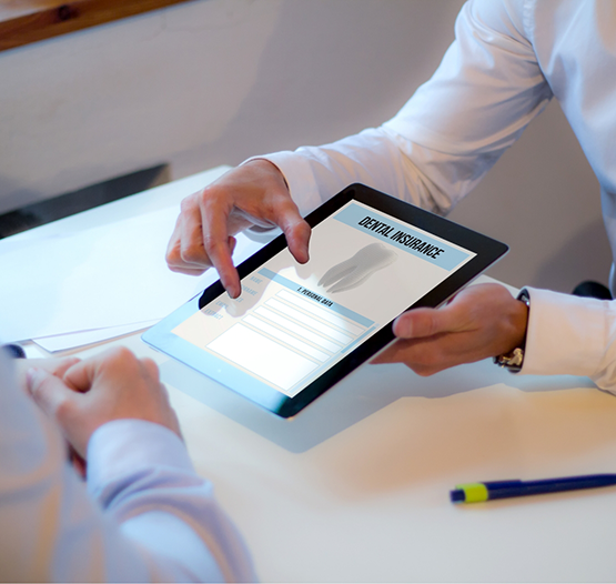 Two people looking at dental insurance information on a tablet