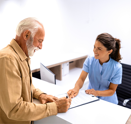 Man signing a form at the dental office