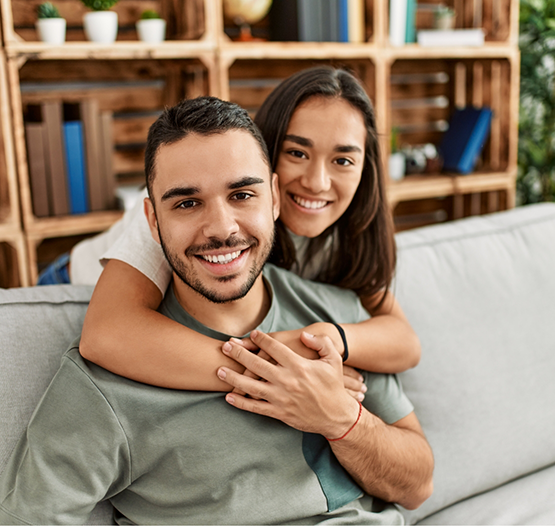 Young man and woman hugging on a couch