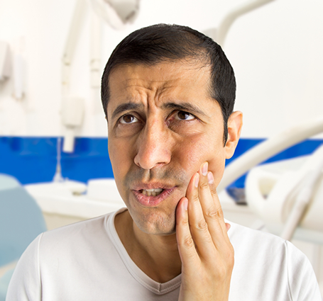 Dental patient touching his face in pain
