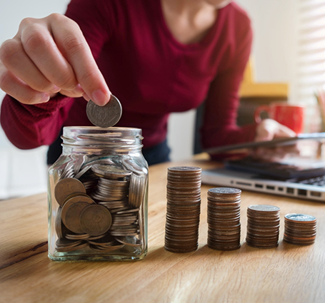 Person taking coins out of a jar and stacking them
