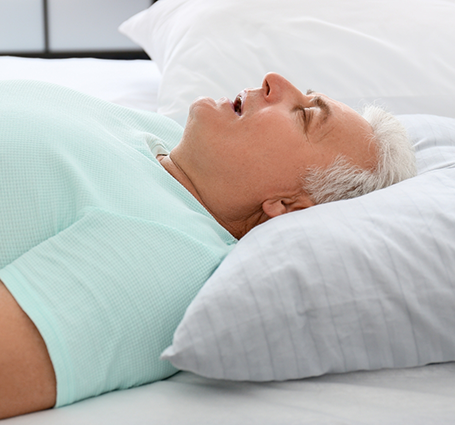 Older man sleeping on his back with his mouth open