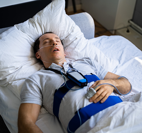 Sleeping man wearing electrodes to check his vitals