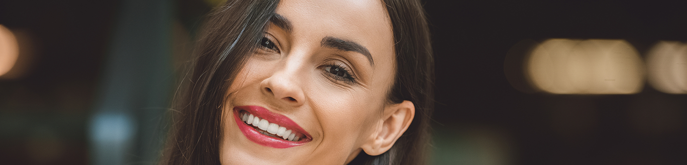 Brunette woman smiling with flawless teeth after cosmetic dentistry in Spring