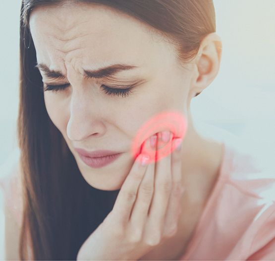 Woman wincing in pain and holding her cheek