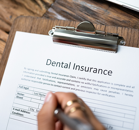 Person filling out dental insurance paperwork
