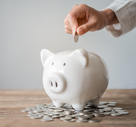 Person putting a coin in a piggy bank