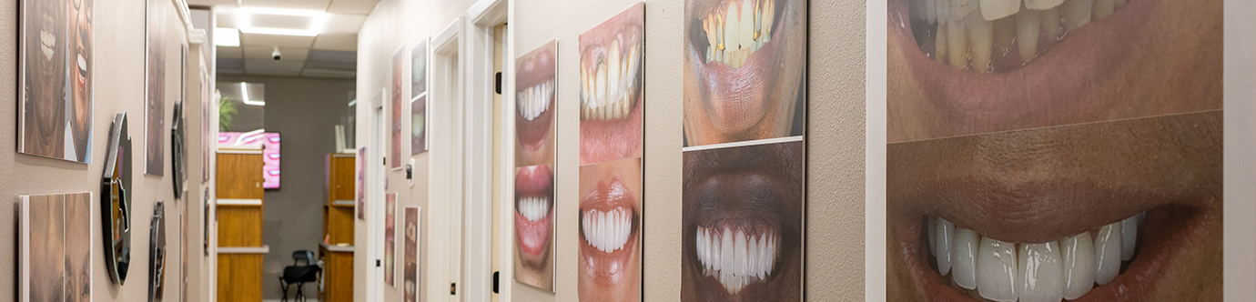 Photos of smiles on the wall of a hallway in Spring Dentist