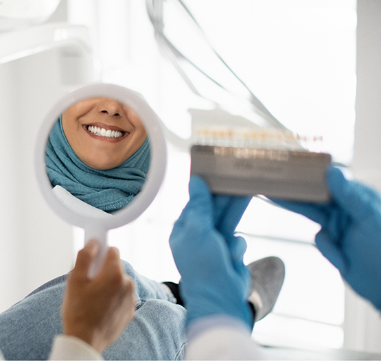Dental patient admiring her smile in a mirror